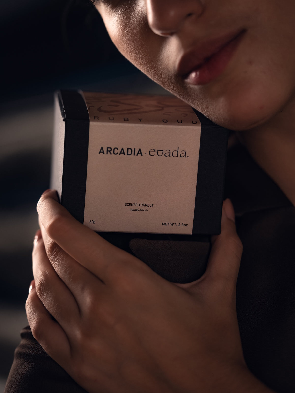 Ruby Oud candle in its gift box, held close