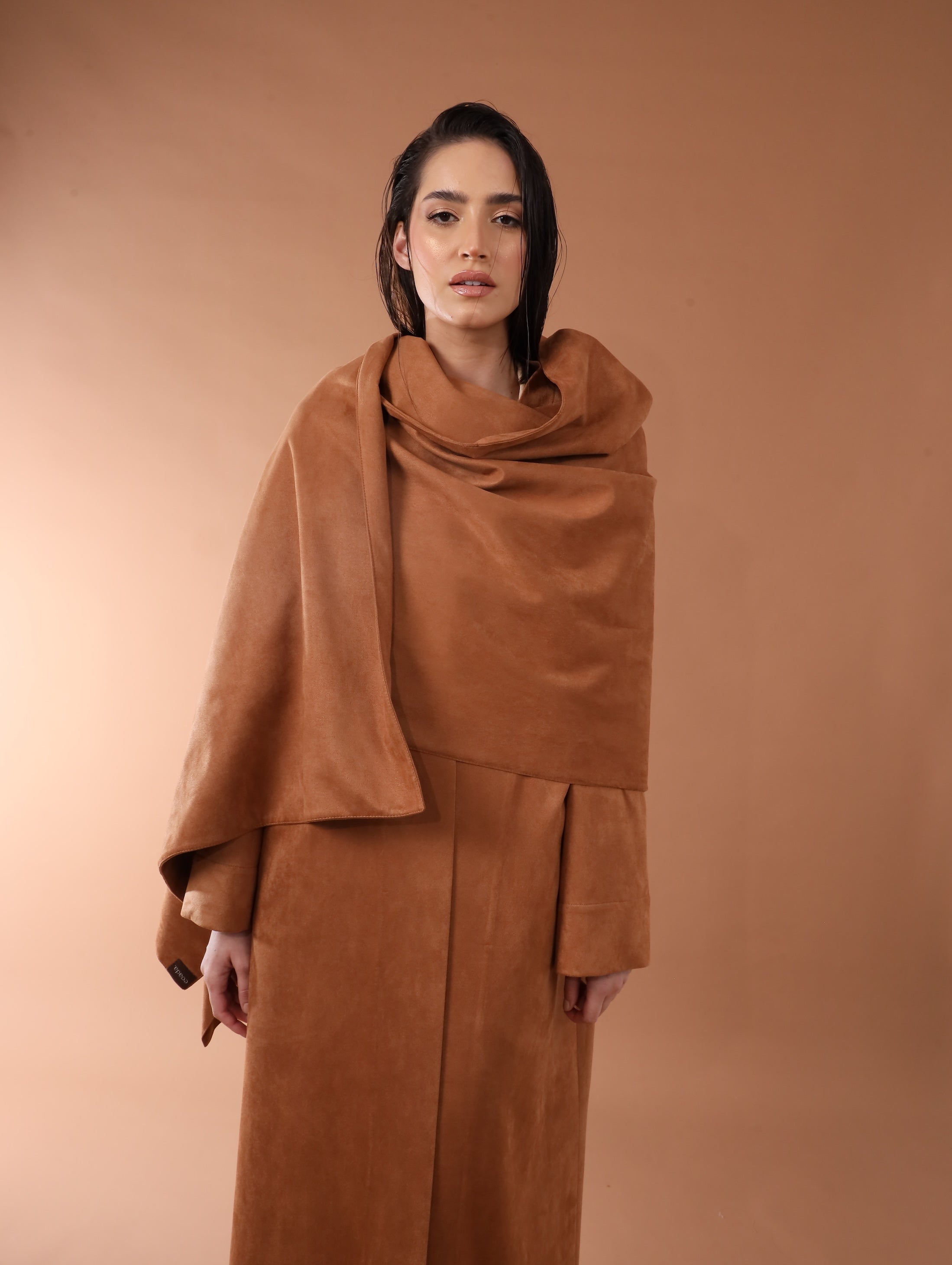 Woman wearing a brown coat against a matching background